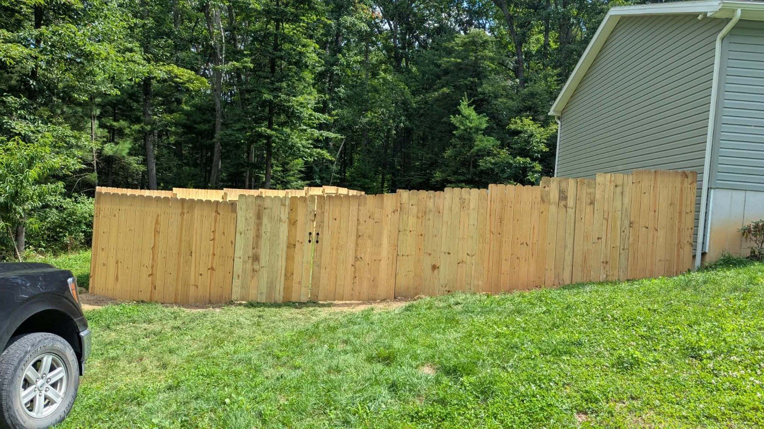 Finished wood privacy fence wrapping a residential yard